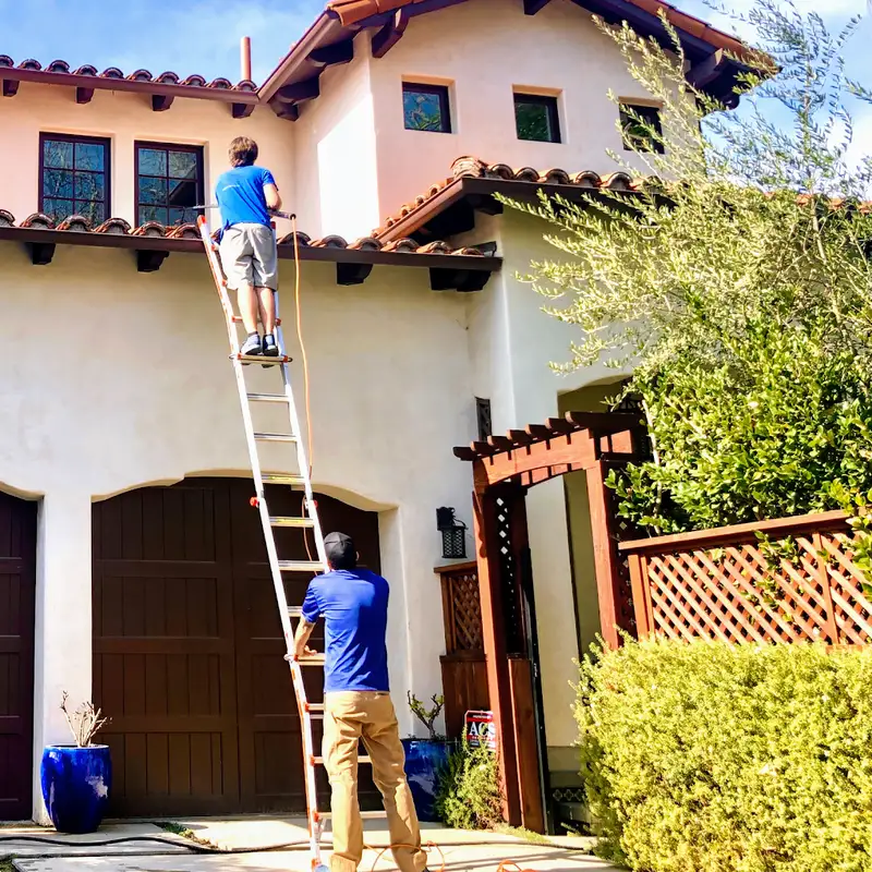 Uniformed Elite Window Cleaning technicians working at height inside luxury interior